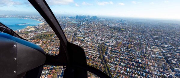 Fly Huber Australia Helicopter EC130 Flying Melbourne Bayside towards Albert Park and Melbourne CBD looking at CBD Skyline